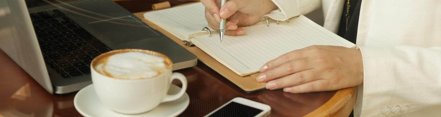 Kaffeetasse, Laptop und Notizbuch – symbolisches Business-Motiv zur strategischen Planung von Kundengeschenken für Hundehalter im Hundetraining.