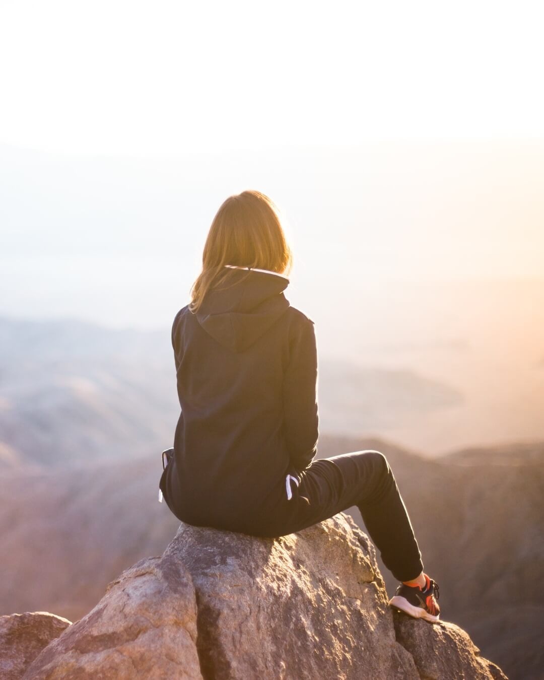 Frau sitzt auf dem Berg 
